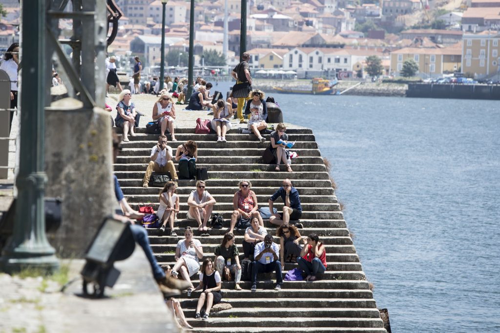 Conference attendees sat on steps in the sunshine