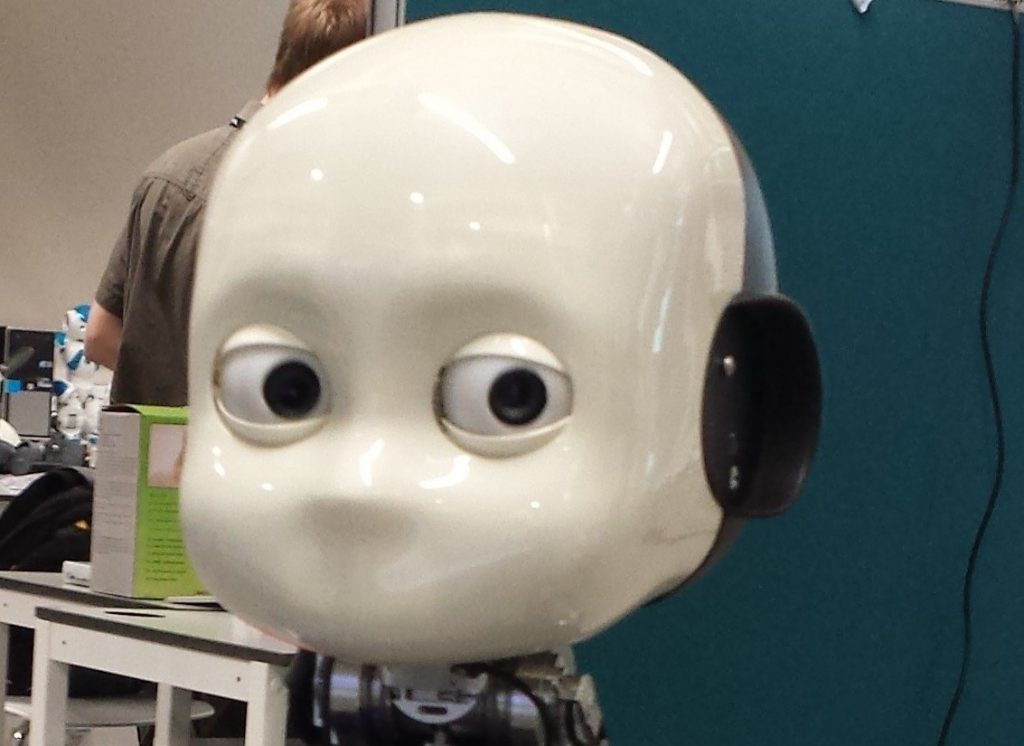 A white robotic face with a mischievous expression