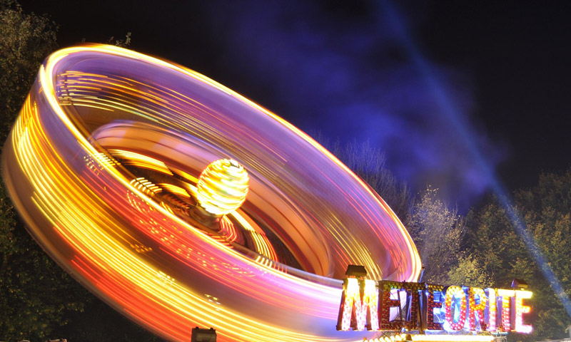 A 'Meteorite' ride spinning so fast that its lights are blurred.