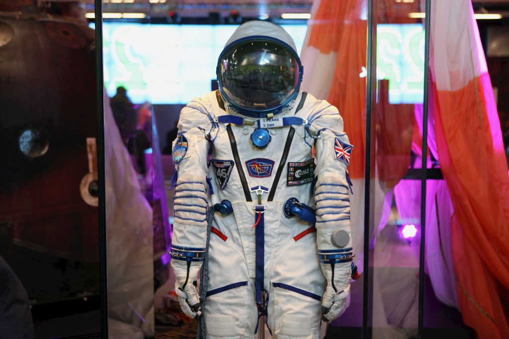 Tim Peake's spacesuit on display at the Museum of Science and Industry, in Manchester. A white astronaut suit with mostly blue badges and a large round helmet with a see-through visor