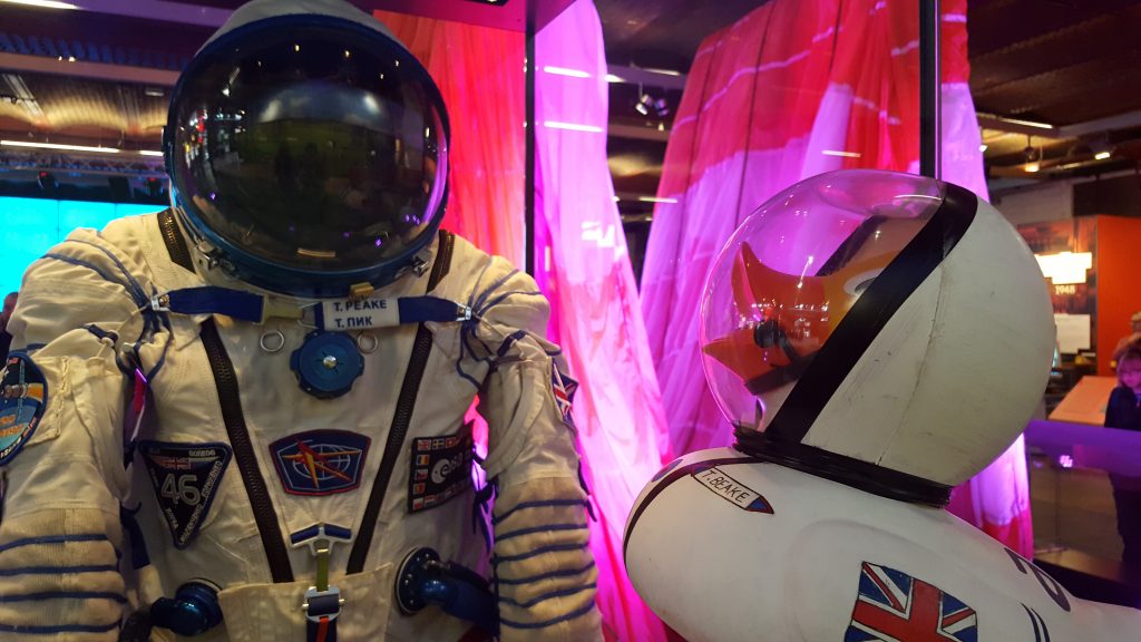 A giant rubber duck looks at Tim Peake's astronaut space suit