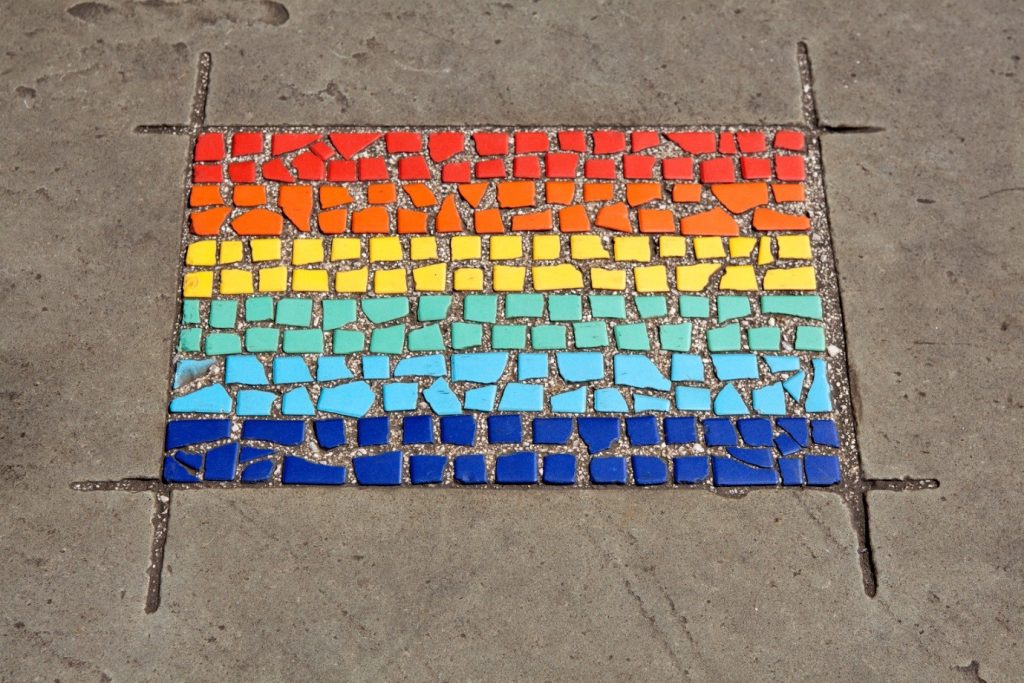 A tile mosaic made out of rainbow colours with red at the top and blue at the bottom