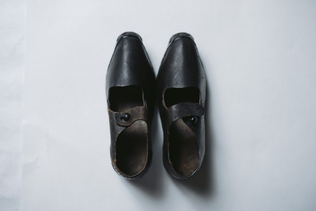 A small pair of black leather clogs