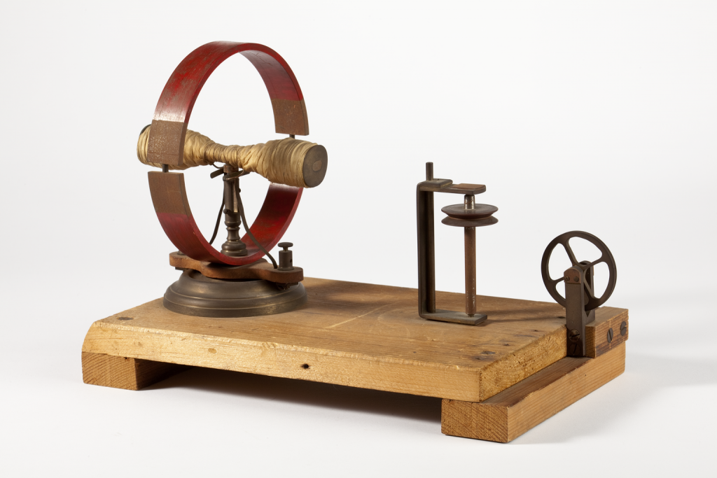 A rudimentary electro-magnetic engine made from brass and wood. 