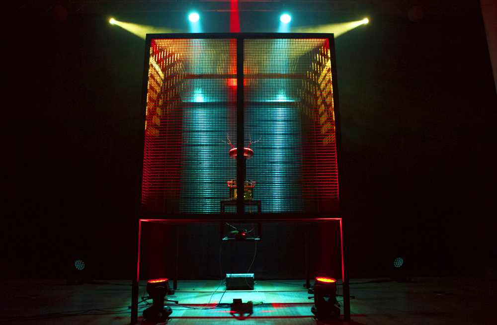 A tesla coil inside a faraday cage makes dramatically coloured sparks