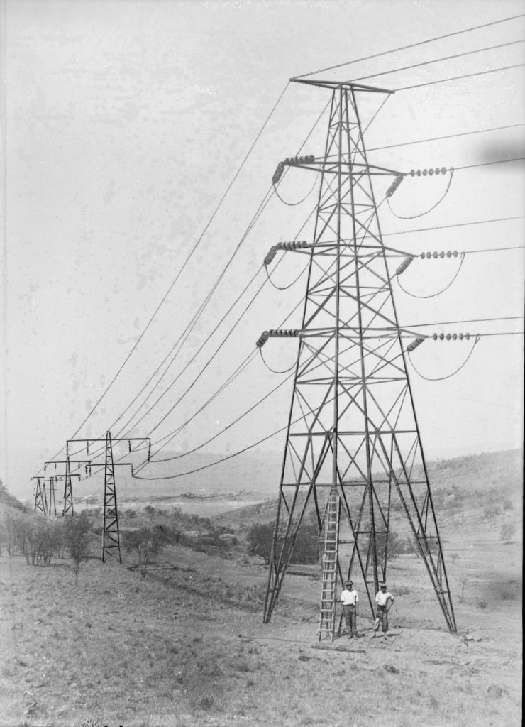 A black and white photograph of steel lattice towers commonly (and incorrectly) known as pylons. 