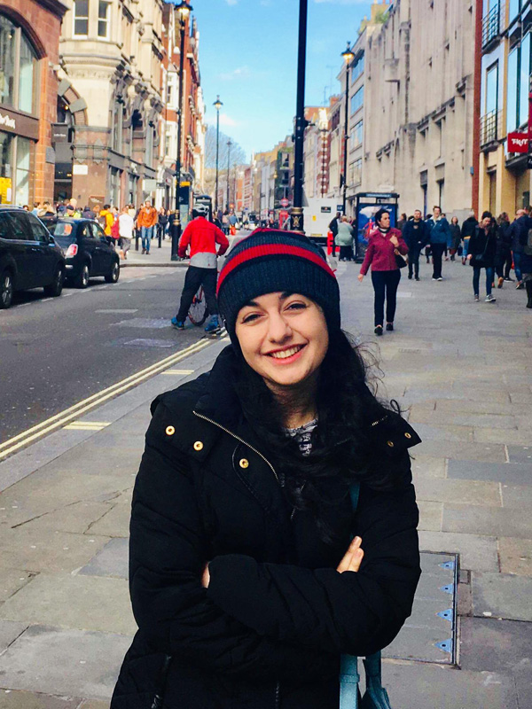 A woman wearing a beanie hat stood on a London street