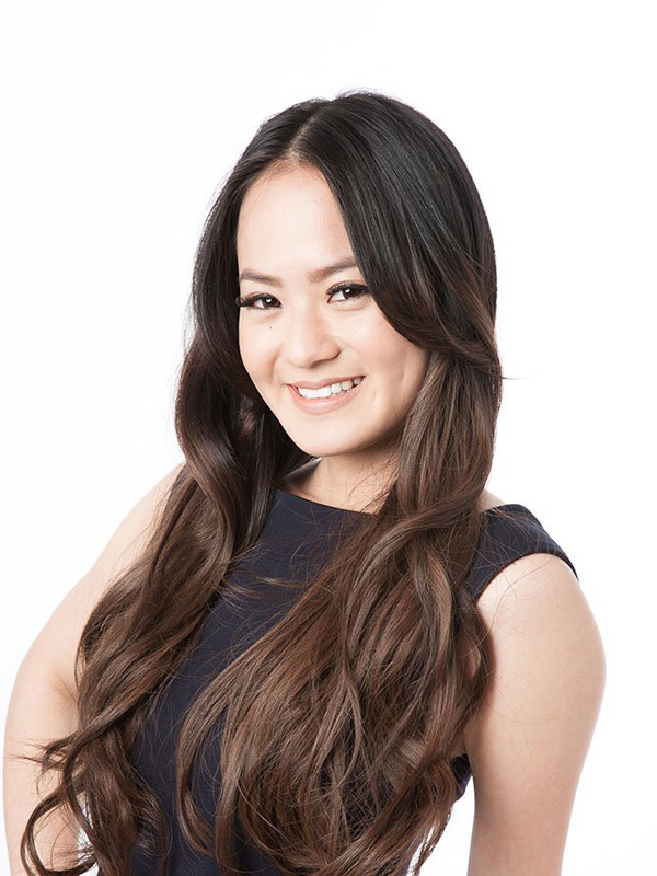 A professional headshot of a woman with long hair