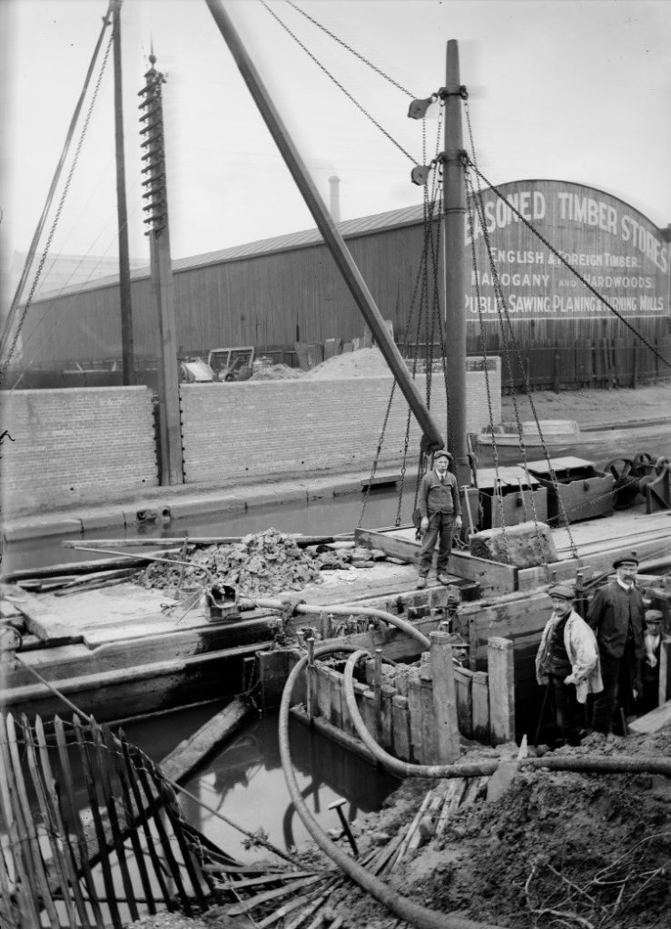 Old photo of three men working on the docks
