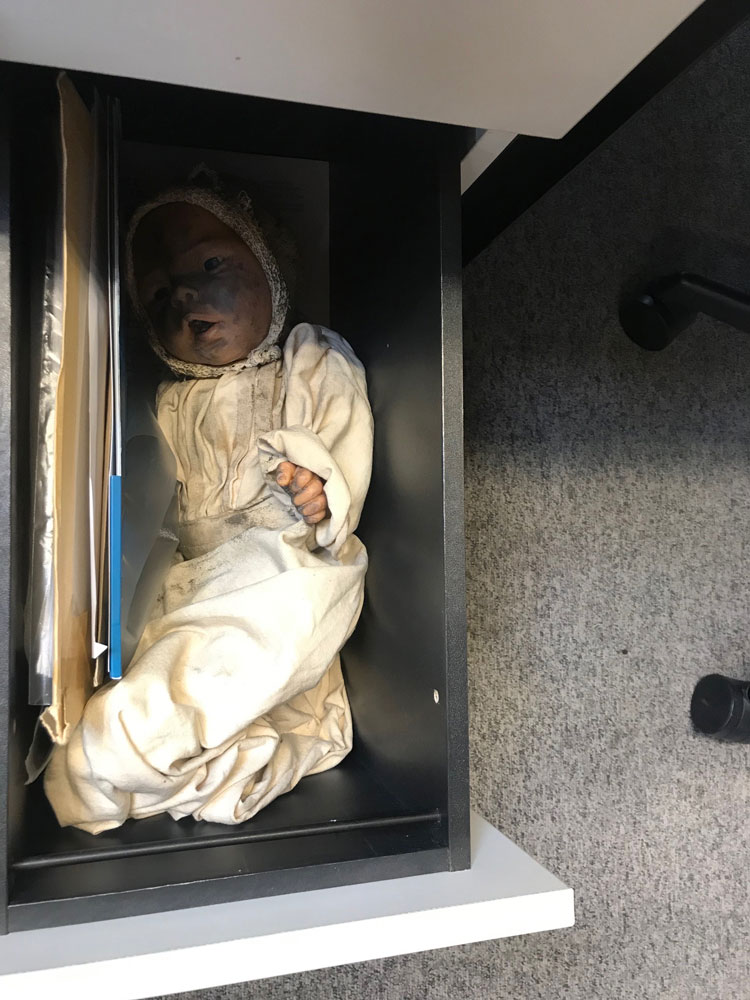 A dirty doll in a drawer