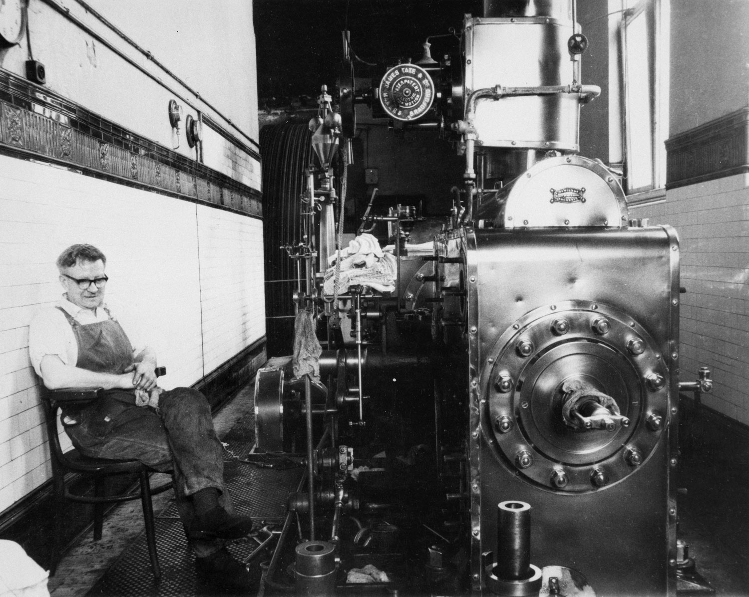 A man sat next to a steam engine