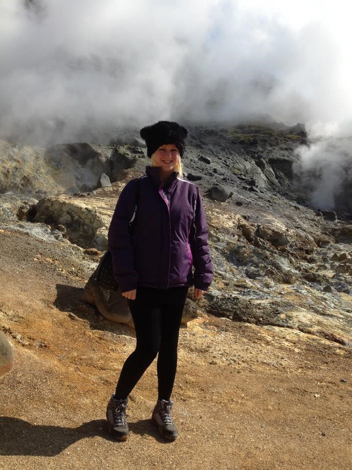 A woman stood on a hill next to a geothermal vent