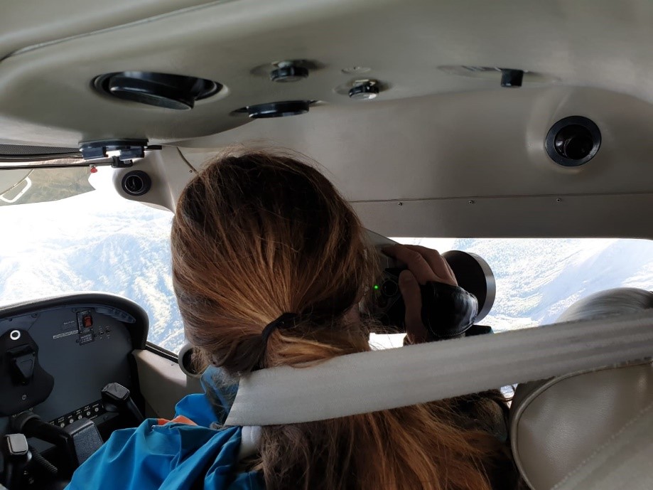 A woman taking a photo from a plane