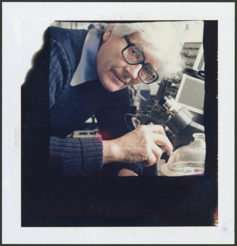 A polaroid colour print of James Lovelock in his laboratory.