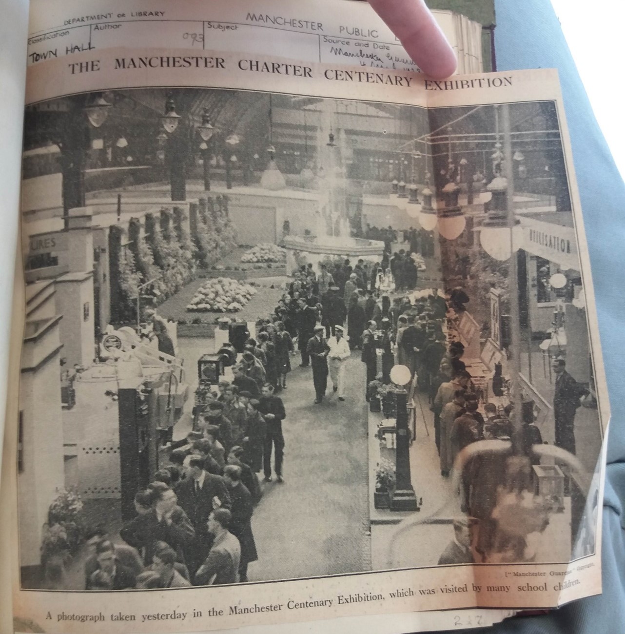 A cut out from a newspaper, of a picture of visitors to an exhibition