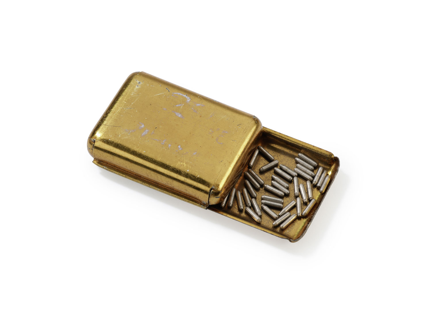 A small golden metal case with metal pellets inside