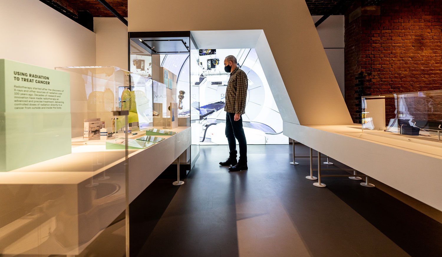 A man looking at a display case in a museum exhibition