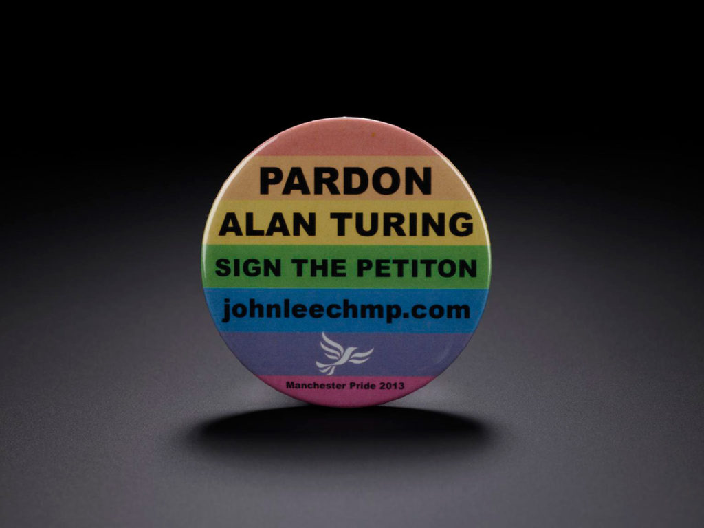 A rainbow coloured badge with 'Pardon Alan Turing' written on it.