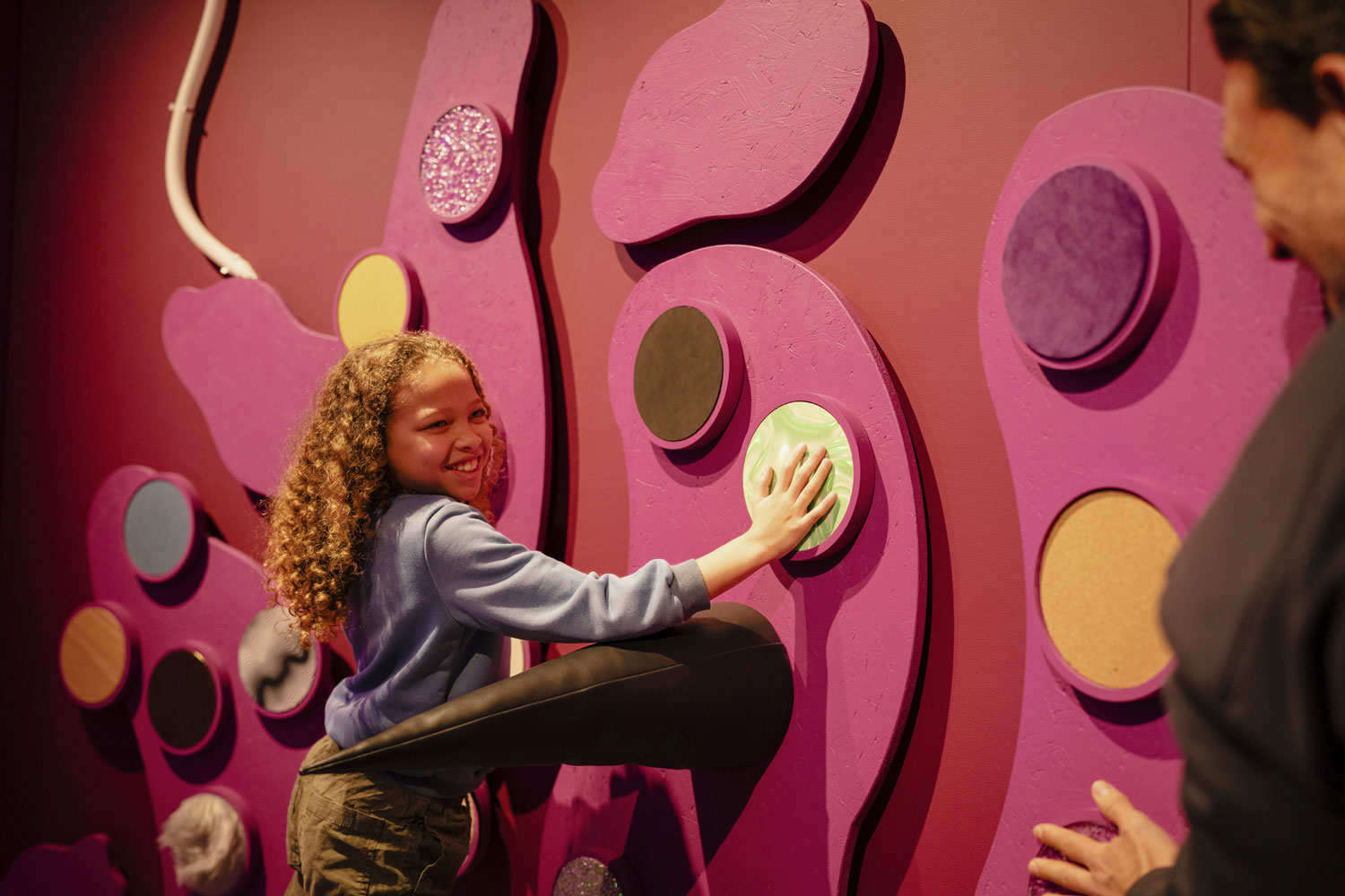 A young girl playing with an interactive museum display