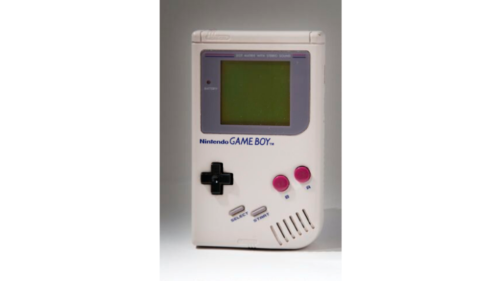 A white retro-looking handheld games console with black and red buttons