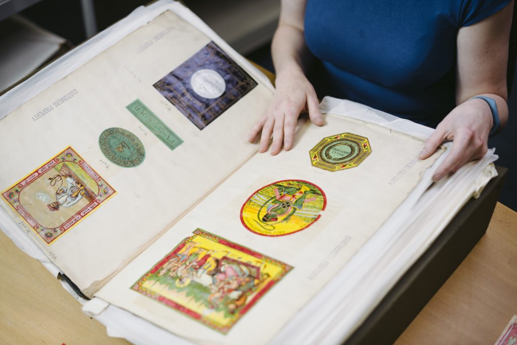 A close up of a large album showing brightly-coloured shipper's tickets