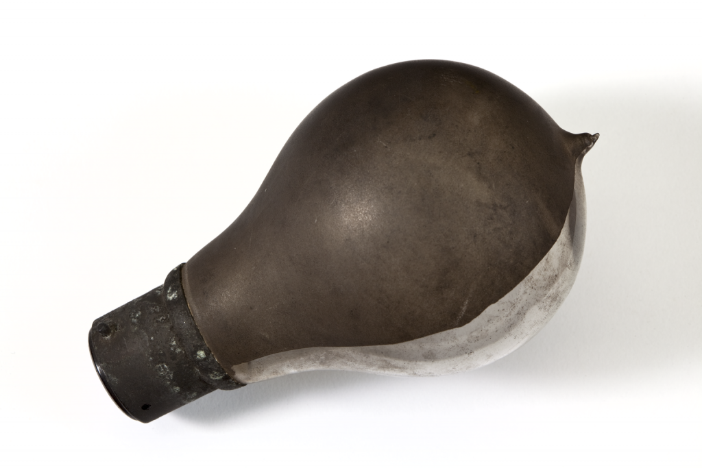 Edison Swan electric bulb with bayonet fitting. Half of the glass lamp has been darkened to create a dimming effect. Removed from the John Rylands Library around 1993.