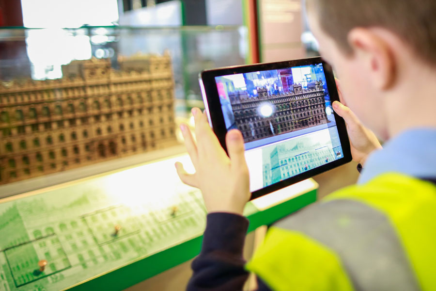 A child in a high-vis jacket holding a tablet