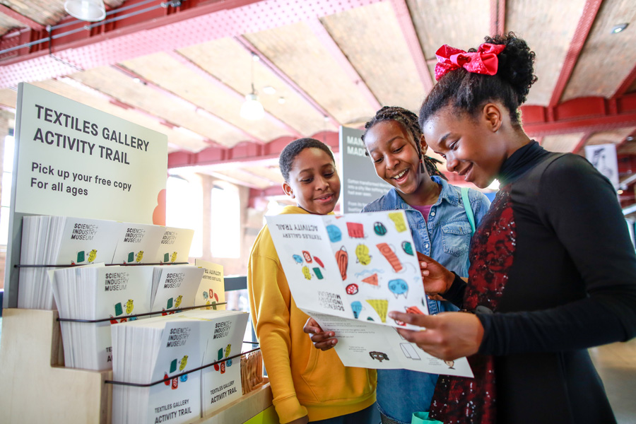 Three children looking at a museum trail map