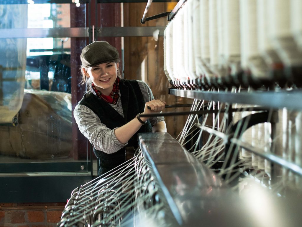 Pippi Carter-Hornsby, the subject of a women in engineering profile, operates a large piece of textiles machinery at the Science and Industry Museum