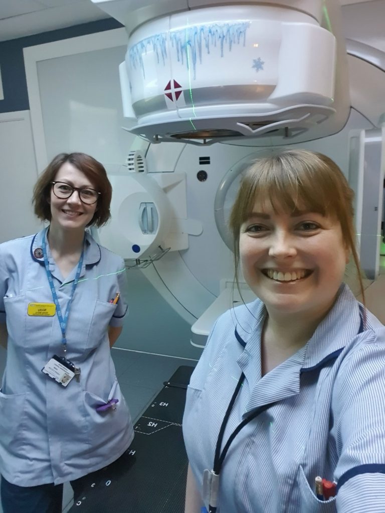 Two nurses stood by hospital equipment