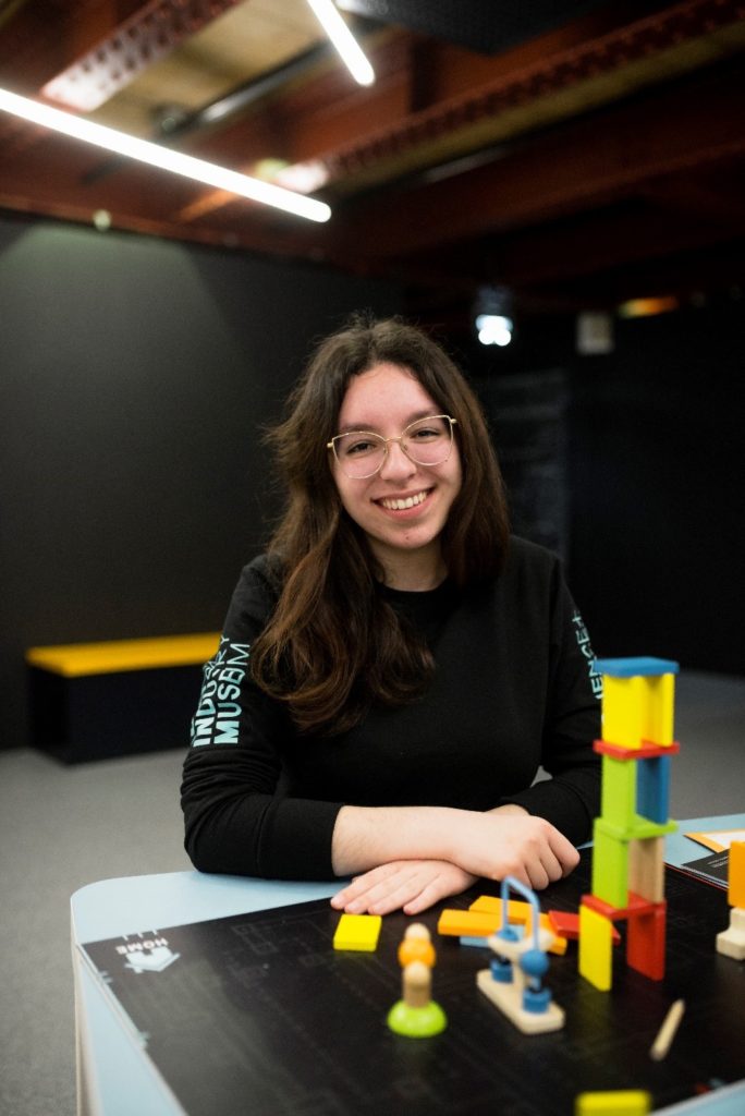 A woman sat at a table with building blocks in front of her