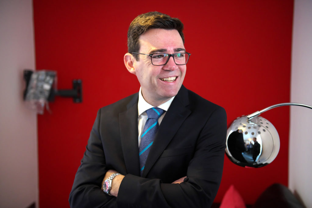 A man in a suit against a red background