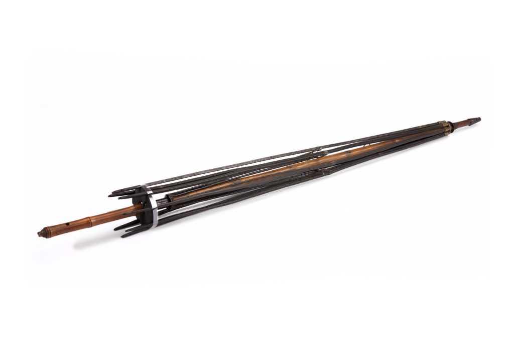 A wooden umbrella frame with no canopy on it