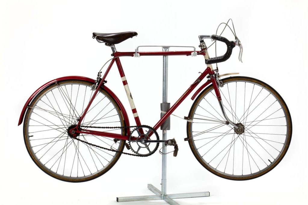 A red road bike on a rack