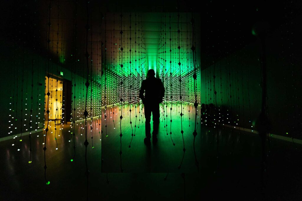 A silhouette of a person stood in an illuminated art installation