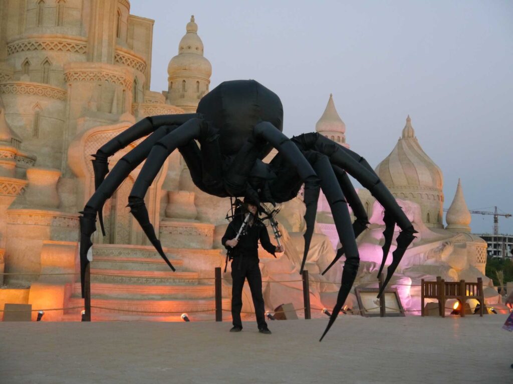 A mechanical spider on display in front of a palace