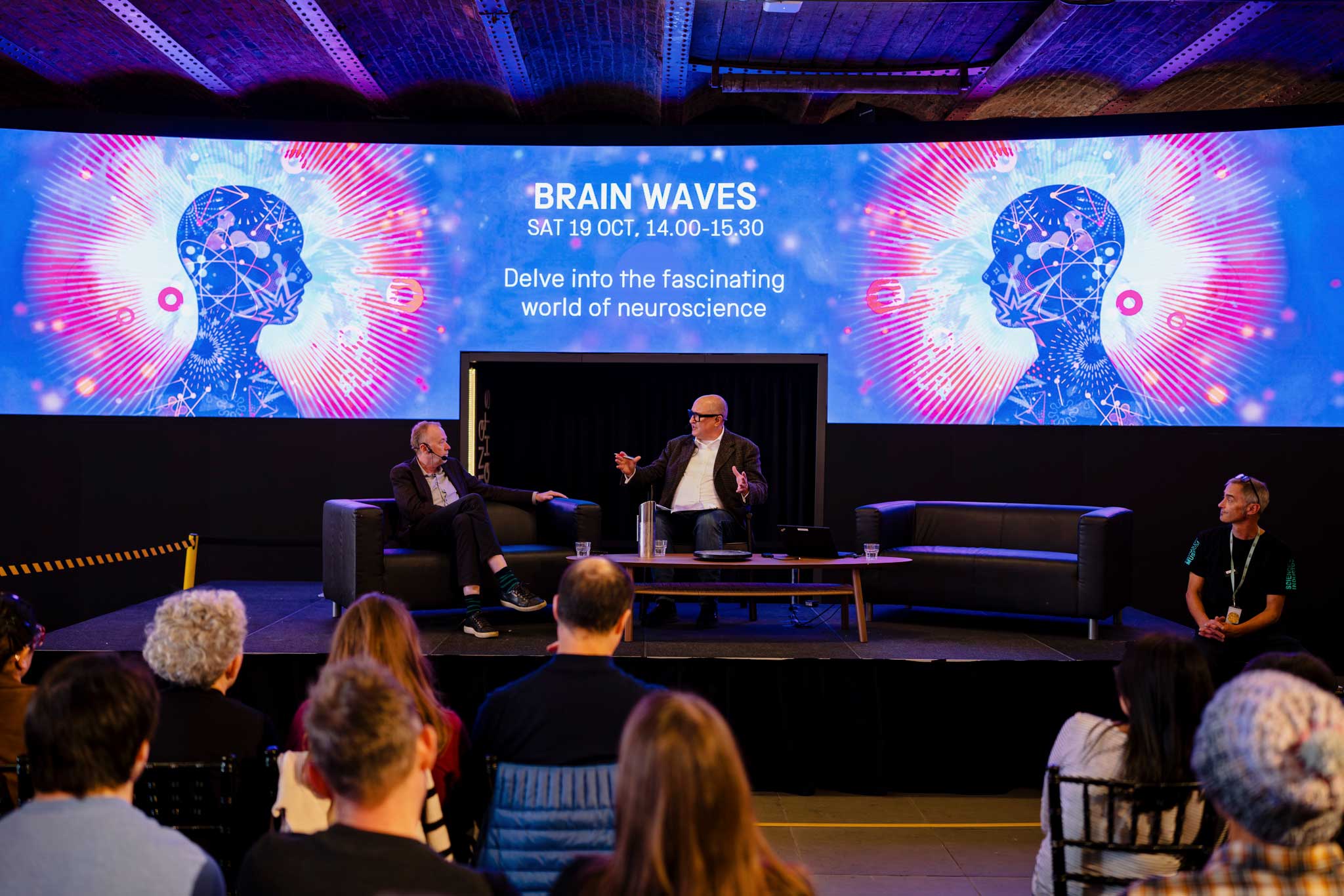 Two men sat down on a stage