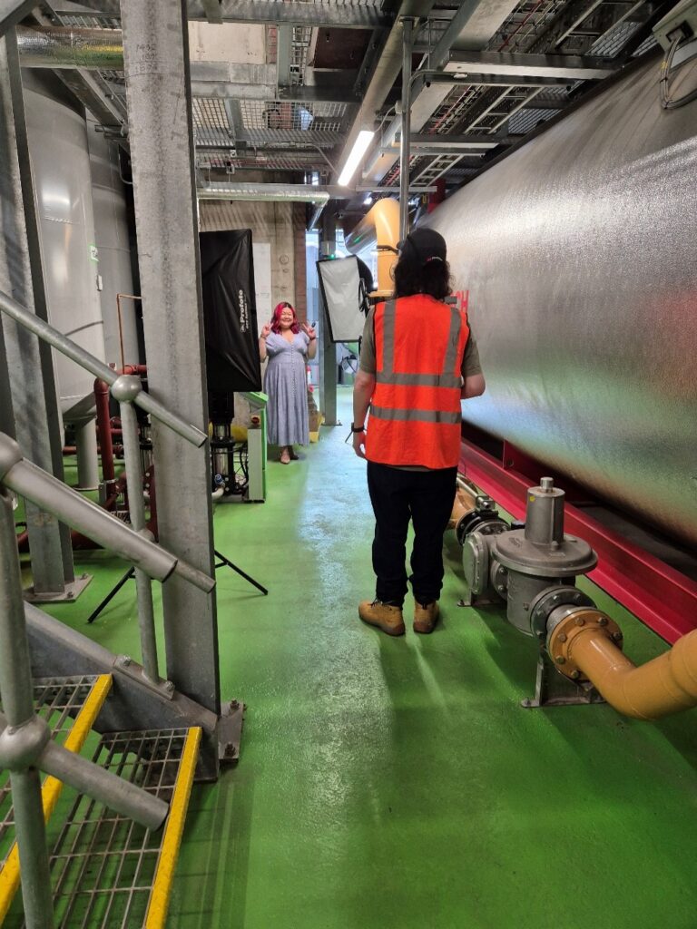 A woman posing for a photo in an industrial setting