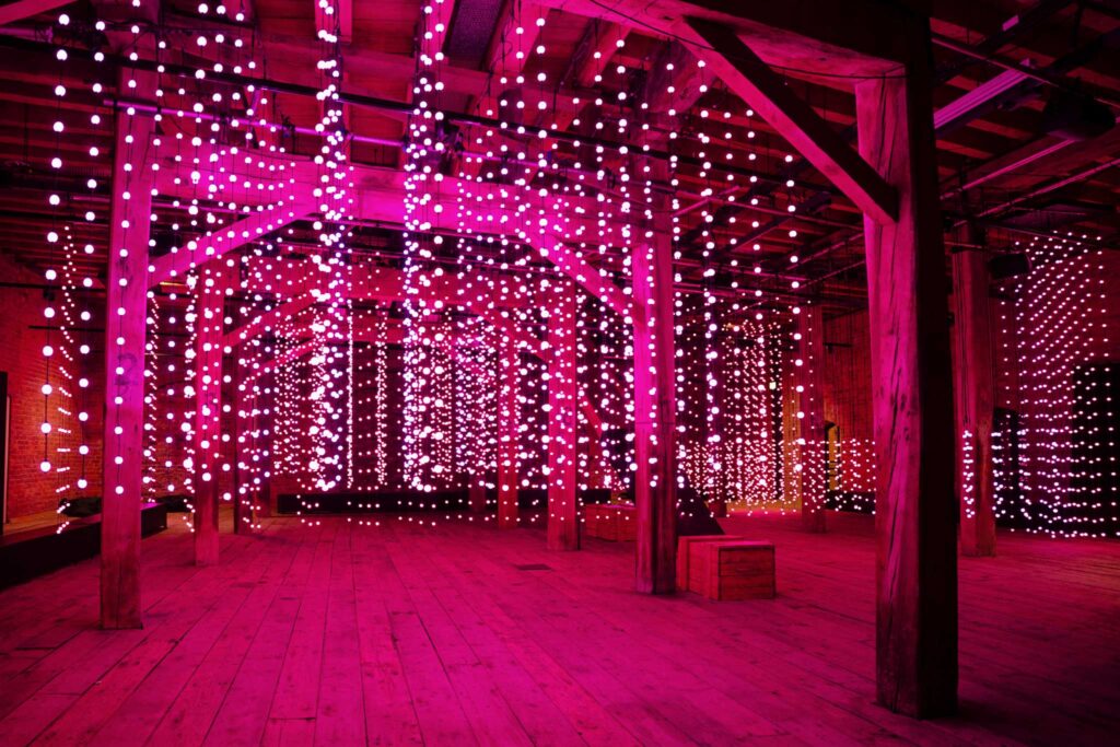 Pink spherical lights hanging from the ceiling of a warehouse