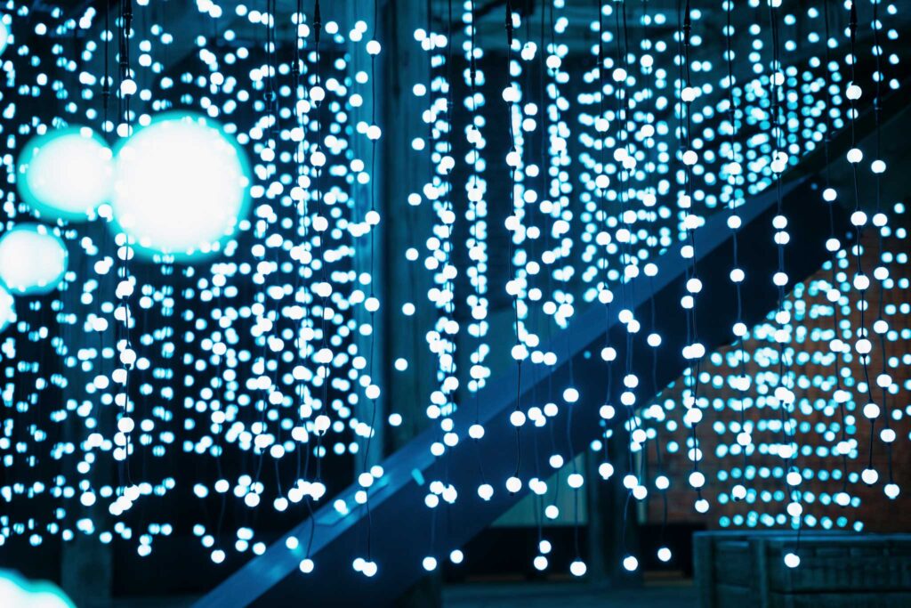 White spherical lights hanging from the ceiling of a warehouse