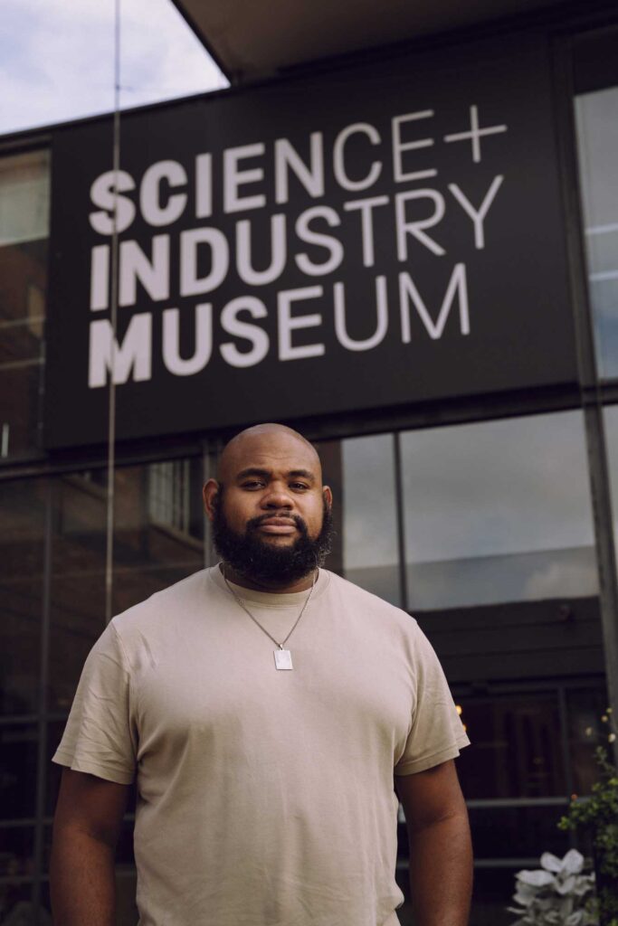 A man stood in front of the Science and Industry Museum with the sign behind him